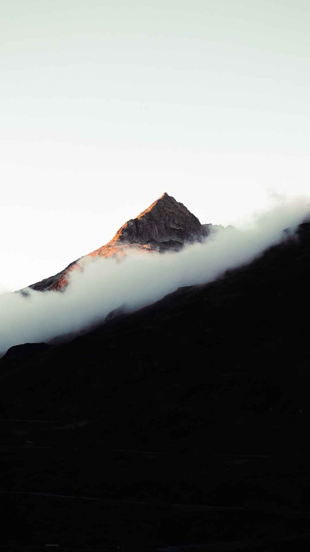 一座被云覆盖的山，背景是一座山