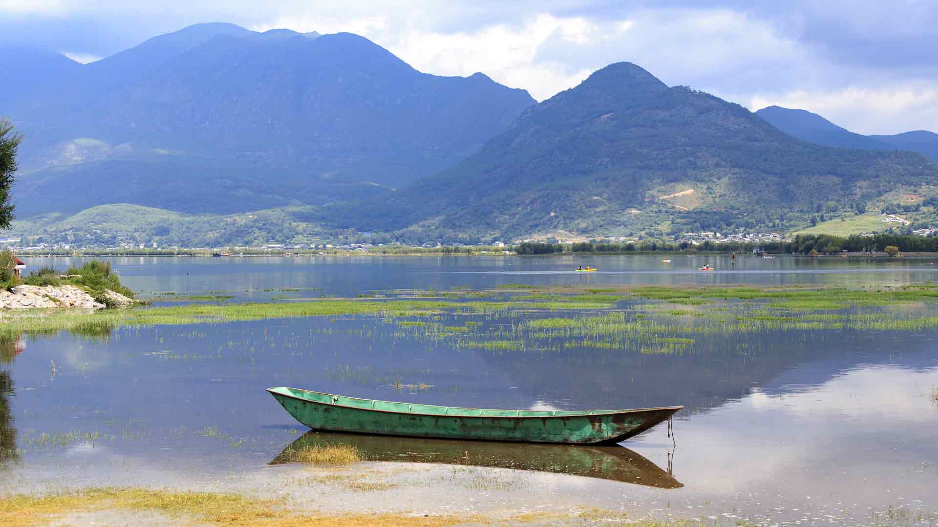 云南丽江湖船只高山风光