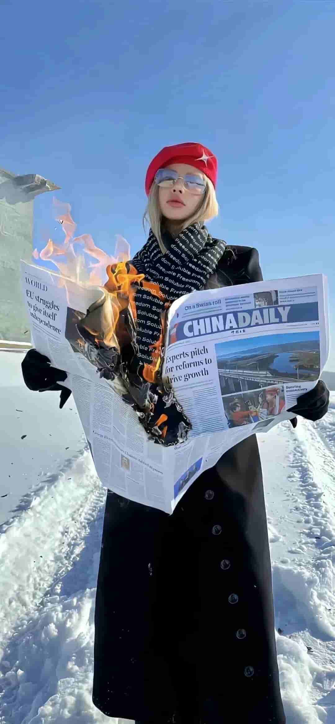 金发女性手持燃烧报纸雪地概念时尚手机壁纸